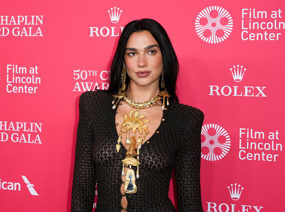 Dua Lipa wearing chocolate-brown Schiaparelli mesh gown with surrealist gold jewelry at Chaplin Award Gala